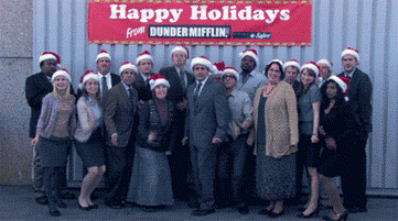 Group of office workers in Santa hats taking a group picture